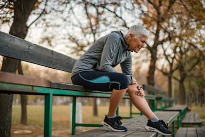 active man in park displays knee pain