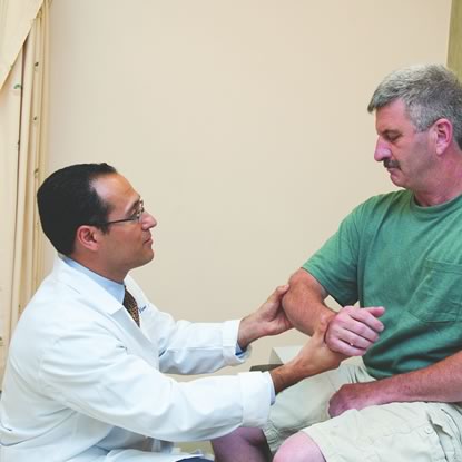 Orthopedist checking out patient elbow